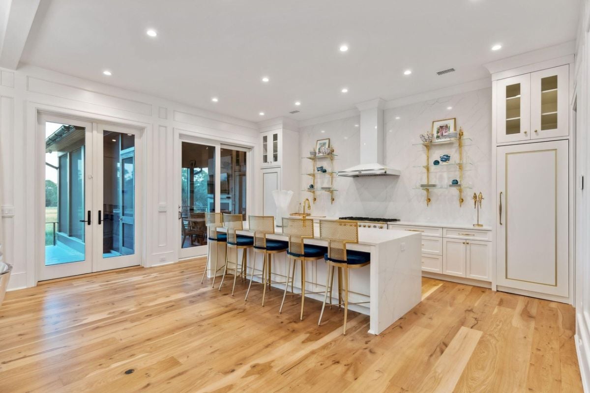 Kitchen with a large island, custom lights and custom cabinets.