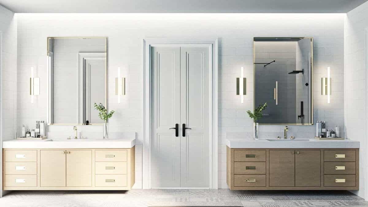 His and her vanities with light wood cabinets, quartz countertops, and brass-framed mirrors.