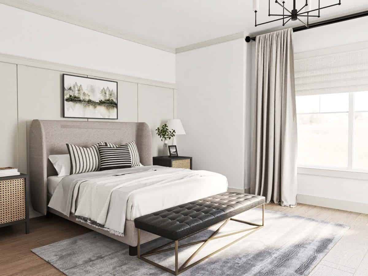 The primary bedroom includes large windows and a tufted bench over the distressed area rug.