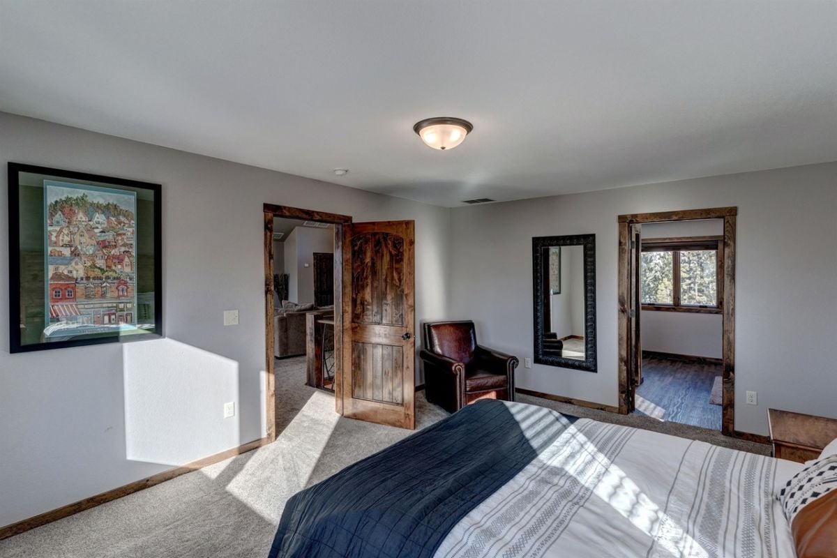Bedroom with a large bed, carpet flooring, and a couch.