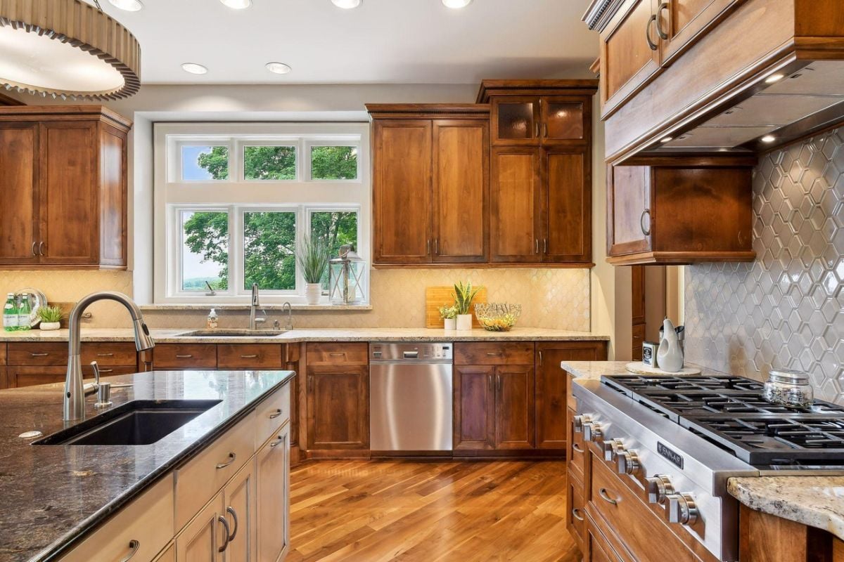 Kitchen with custom lights, stainless steel appliances and custom cabinets.