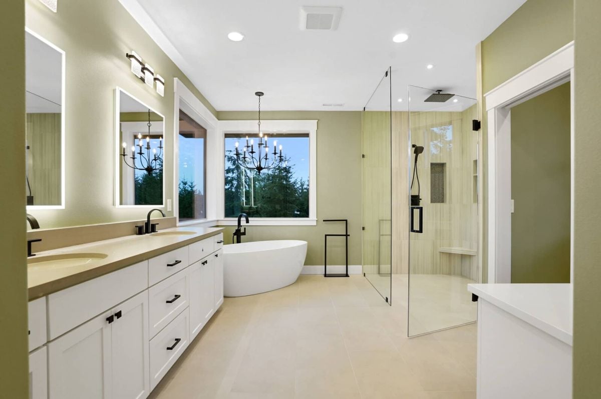 Bathroom with a sink, soaking tub, shower and a chandelier.