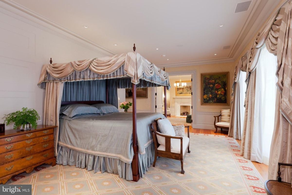 Bedroom with a large bed, wood flooring, a large rug and custom lights.