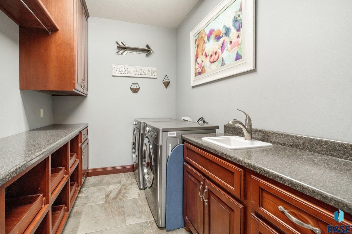 Laundry room with a sink, granite countertops. washer and dryer.