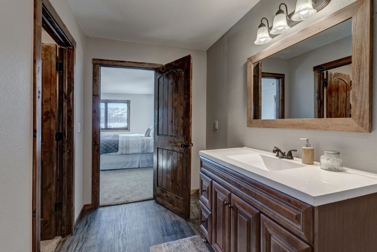 Bathroom with wooden vanity and wood flooring.