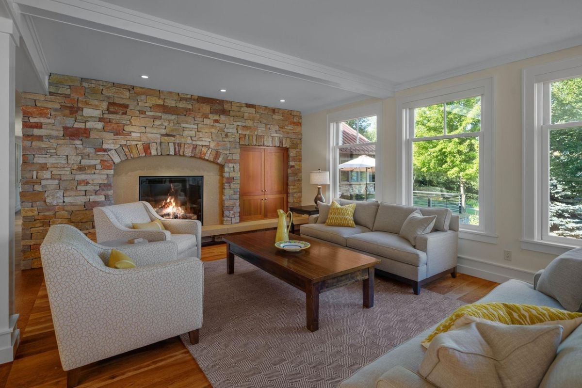 Living room with couches, wooden table and a fireplace.