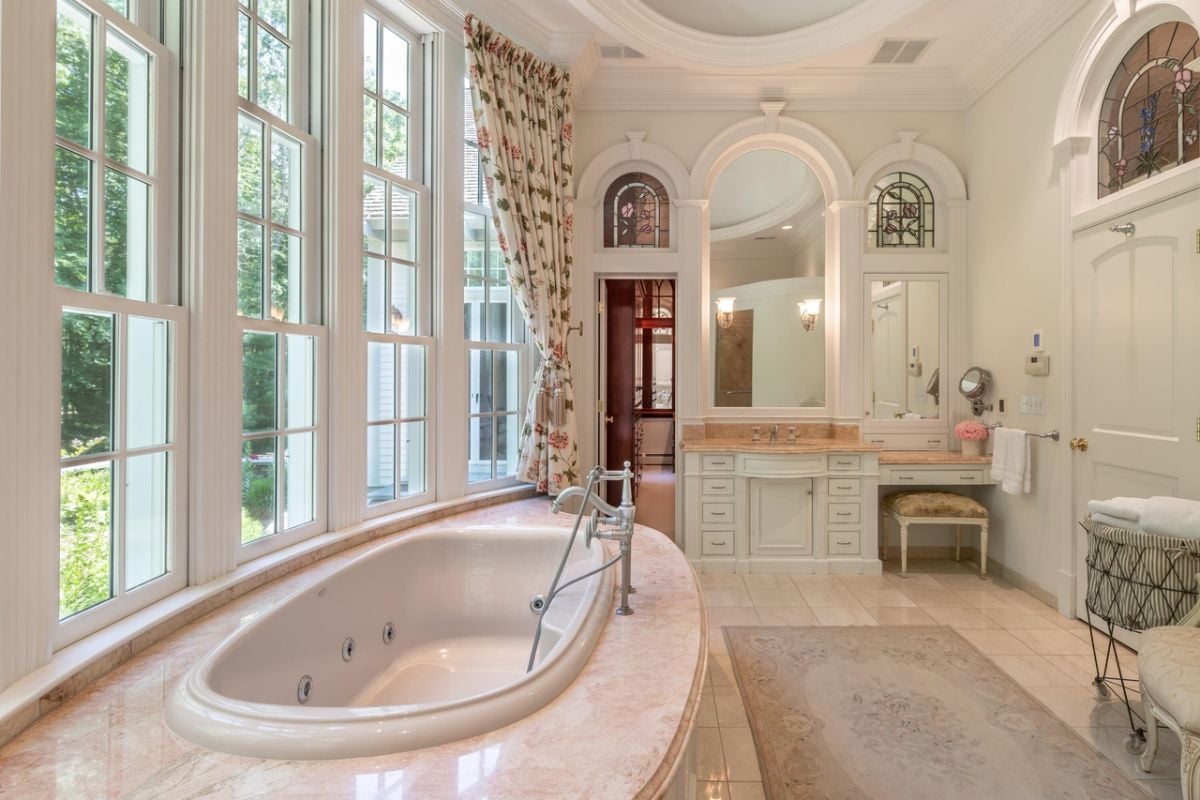 Bathroom with sink, mirrors, soaking tub and glass walls.