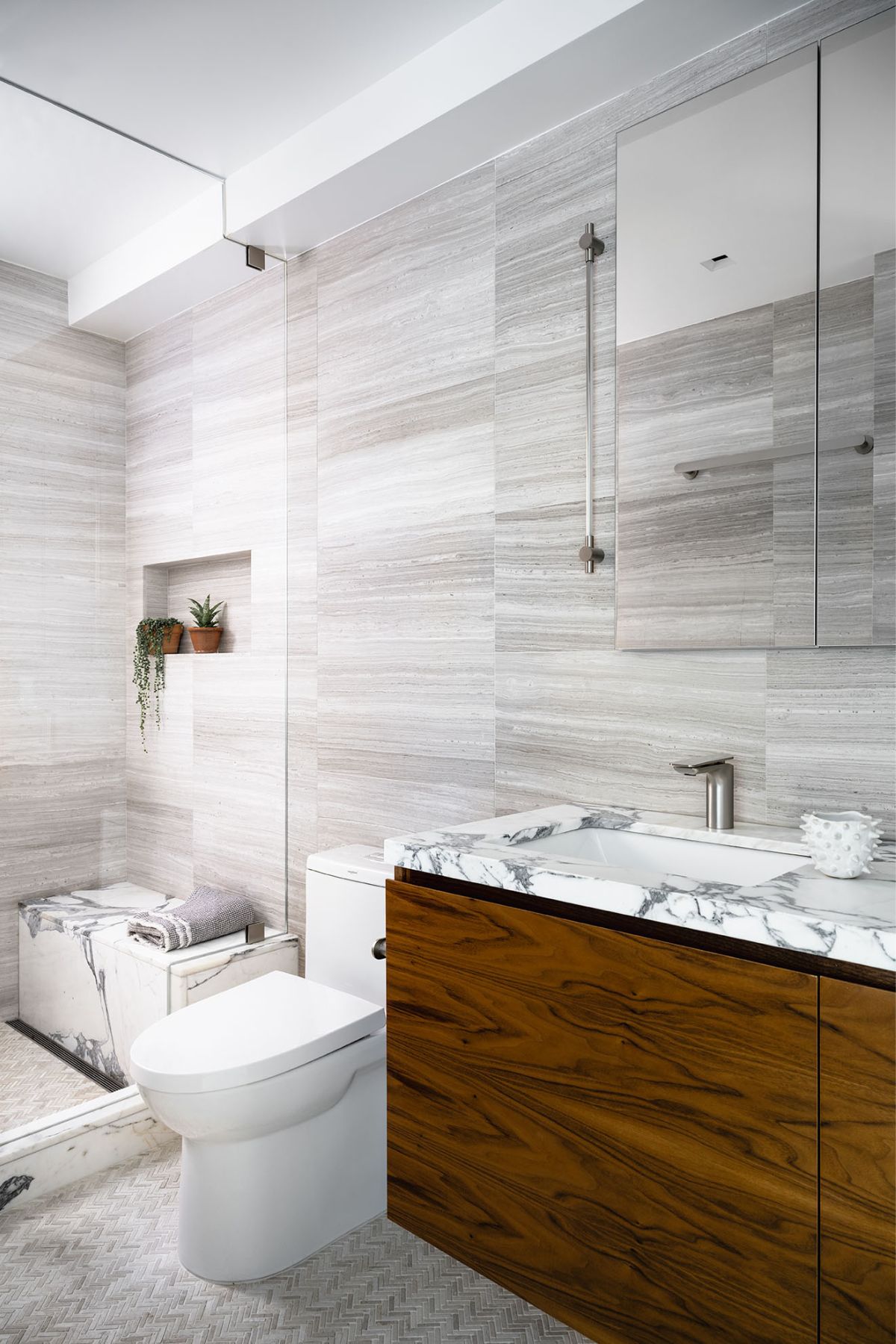 a bathroom with sink, toilet and a marble bench