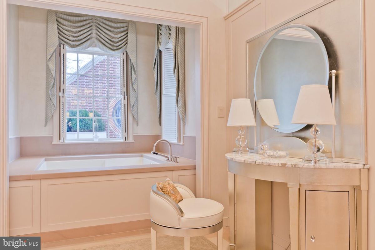 Bathroom with a soaking tub, glass windows and a mirror.