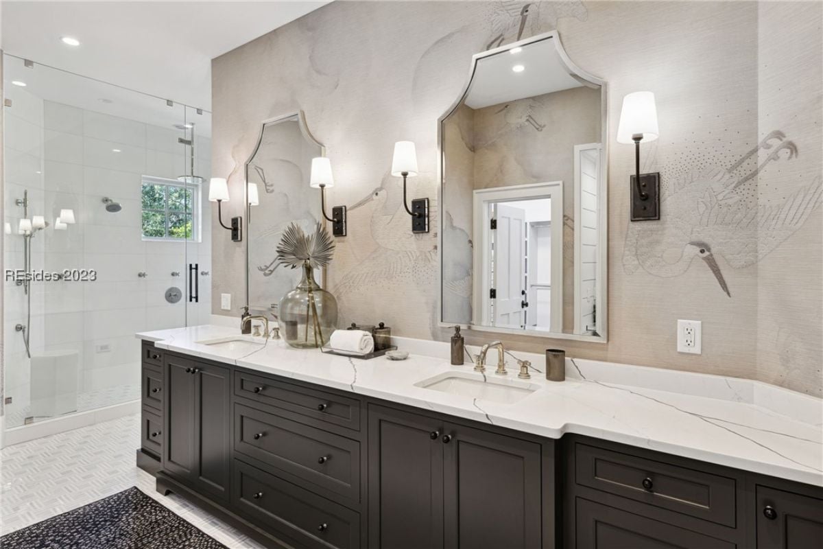 Bathroom with dual sinks, custom lights and a walk-in shower.