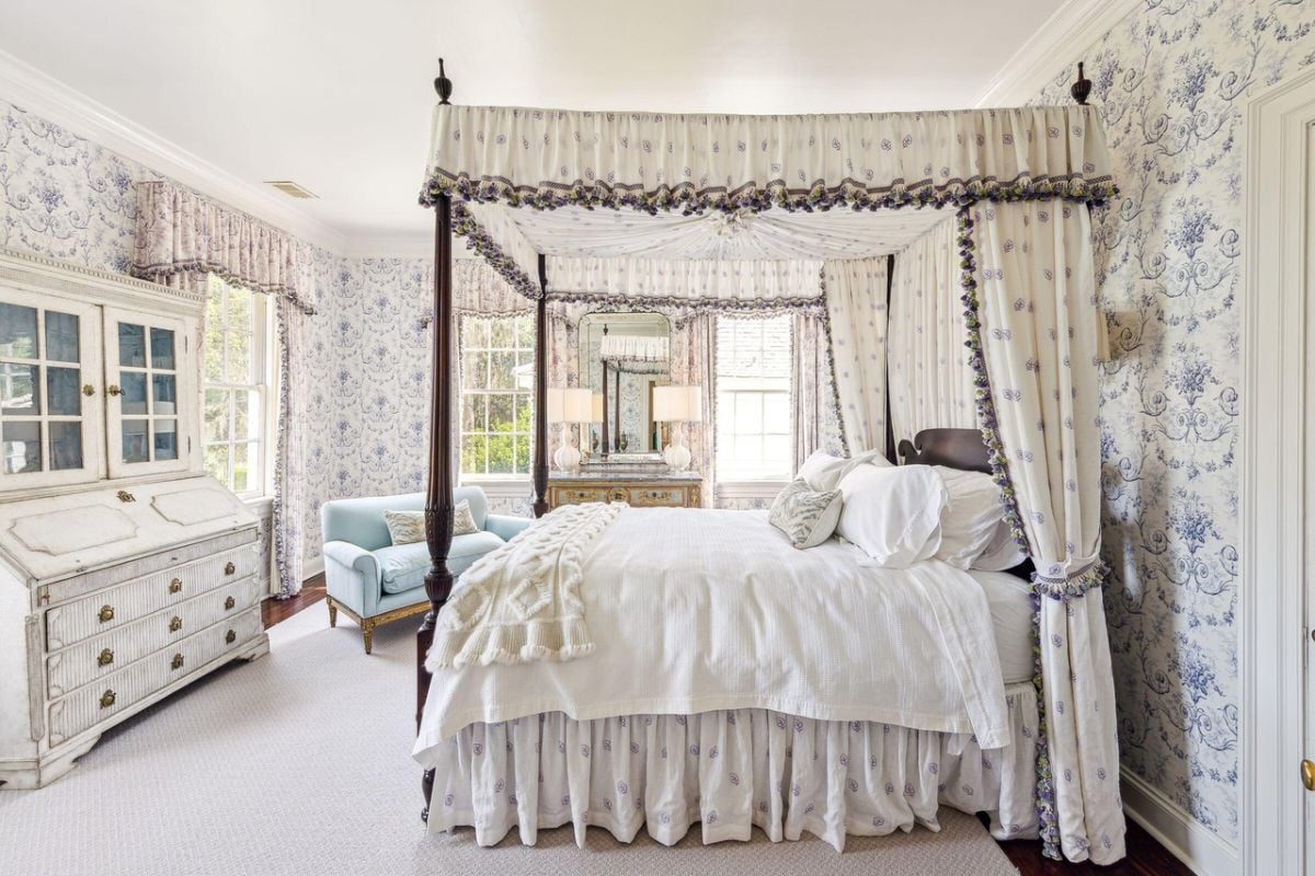 Bedroom with a large bed, carpet flooring, couch and glass windows.