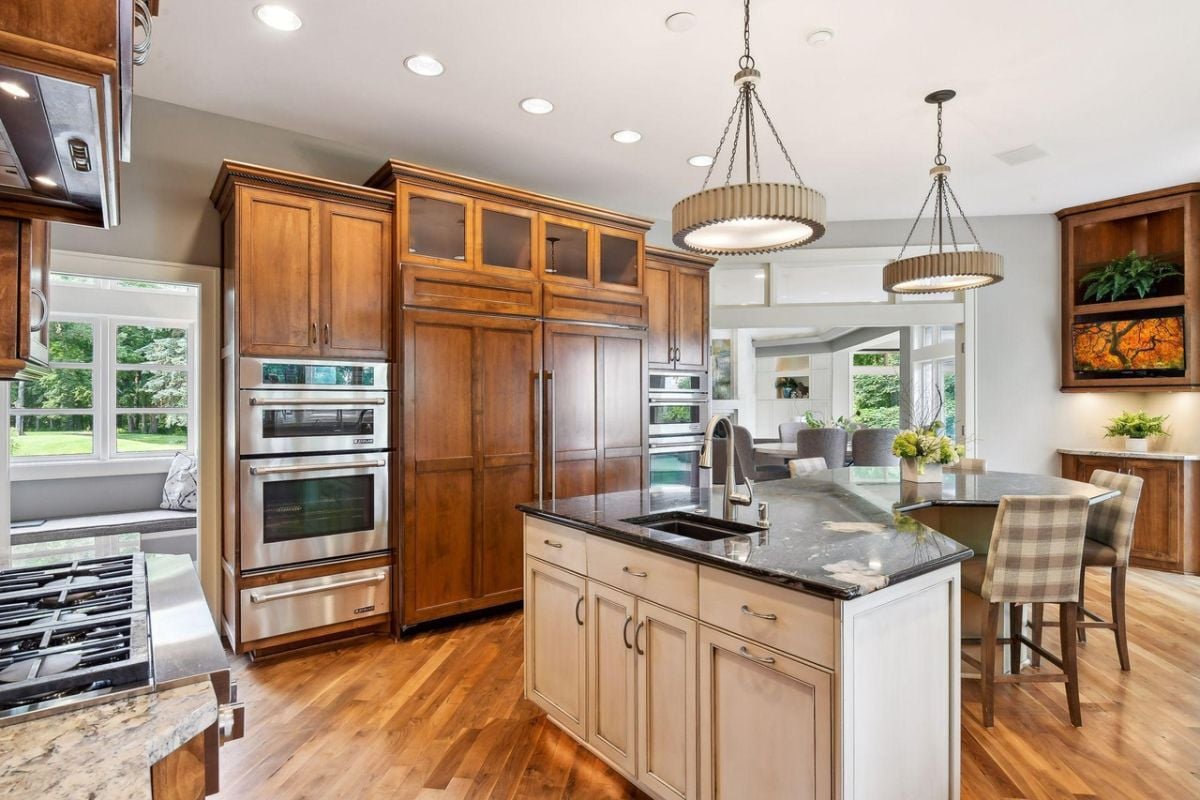 Kitchen with a breakfast area, custom lights, stainless steel appliances and custom cabinets.