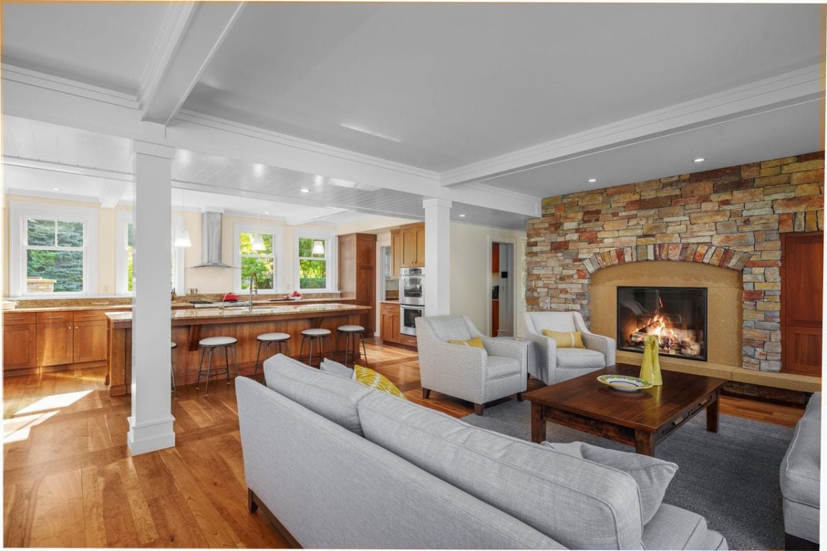 Living room with couches, wooden table and a fireplace.