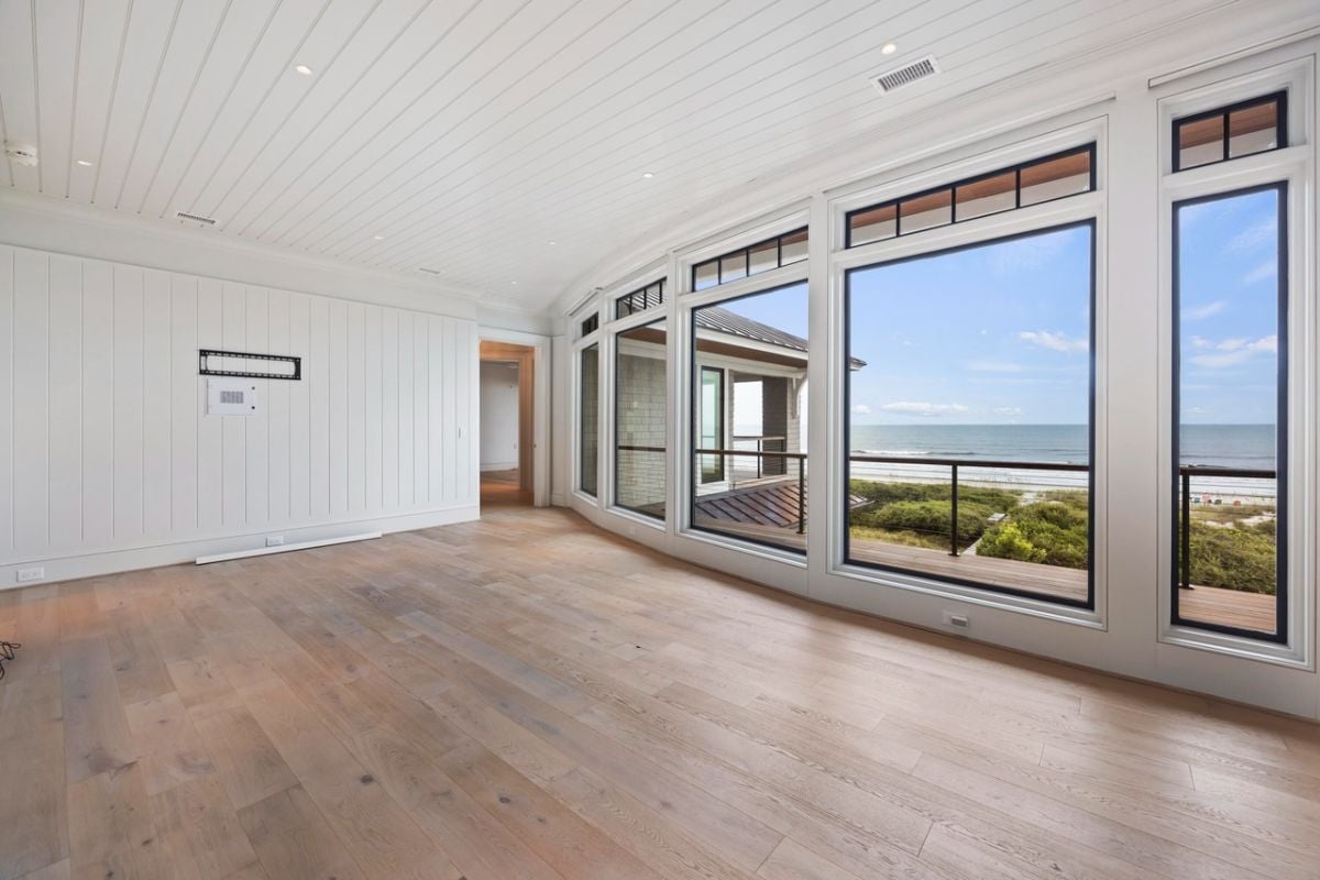 Recreation room with wood flooring, custom lights and glass walls.