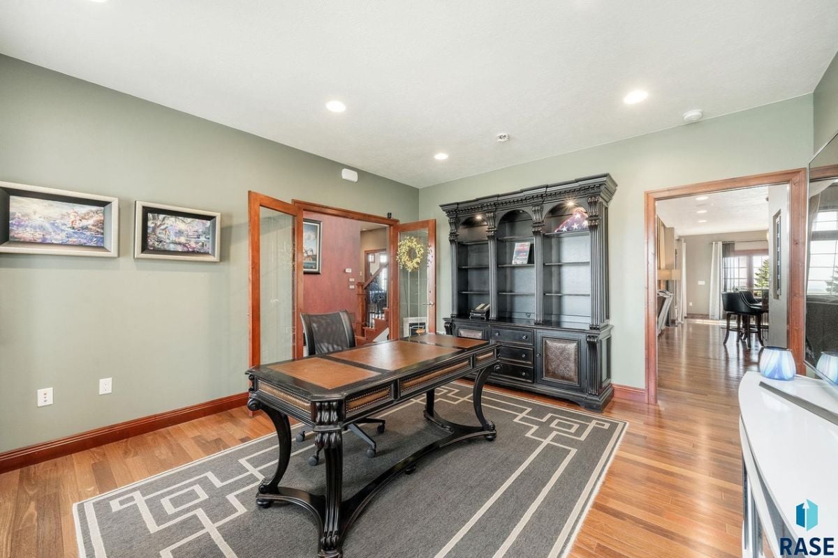 Home office with a desk, chair and a large rug.