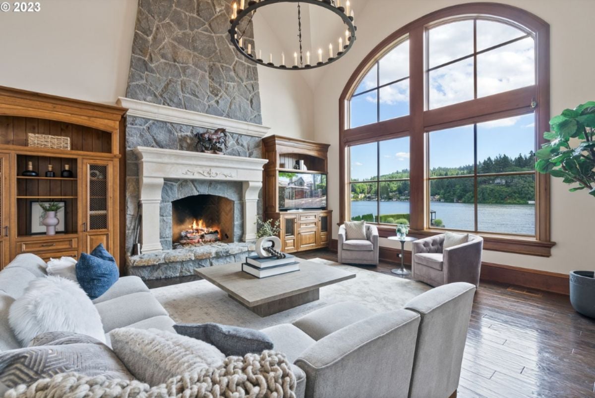 Living room with couches, fireplace and chandelier.