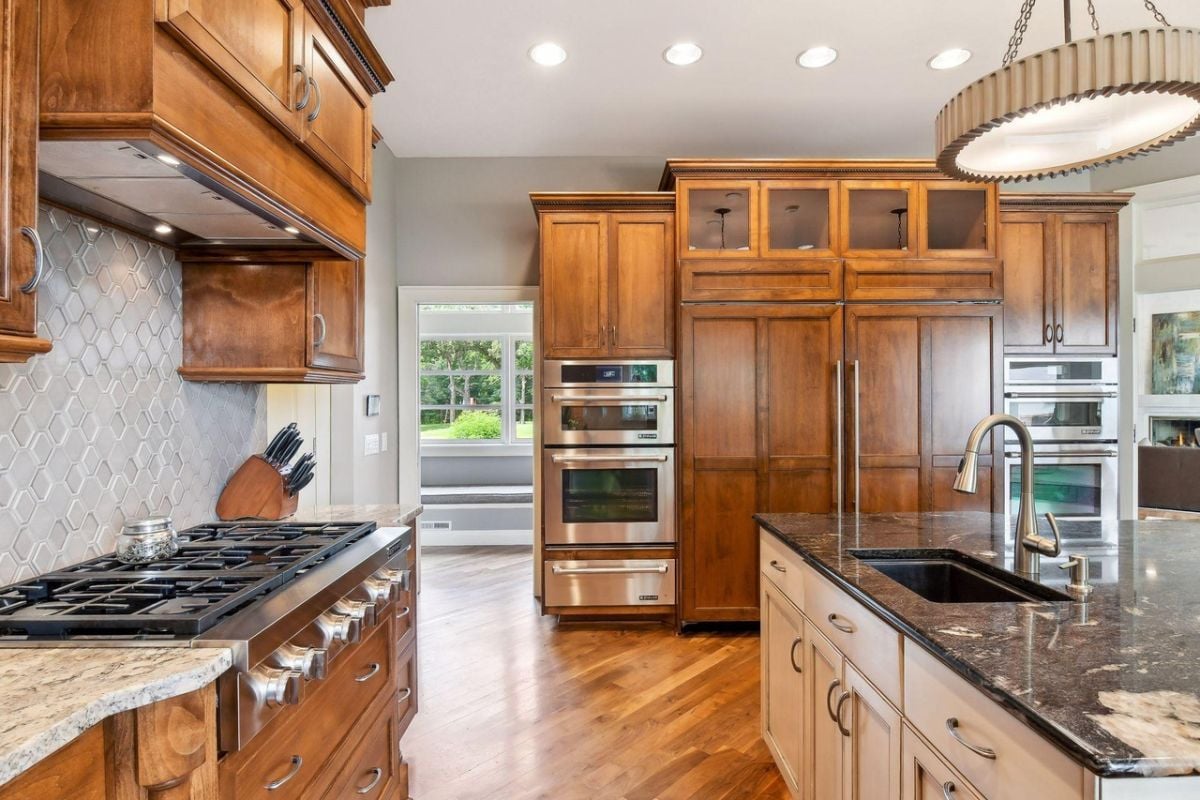 Kitchen with custom lights, stainless steel appliances and custom cabinets.