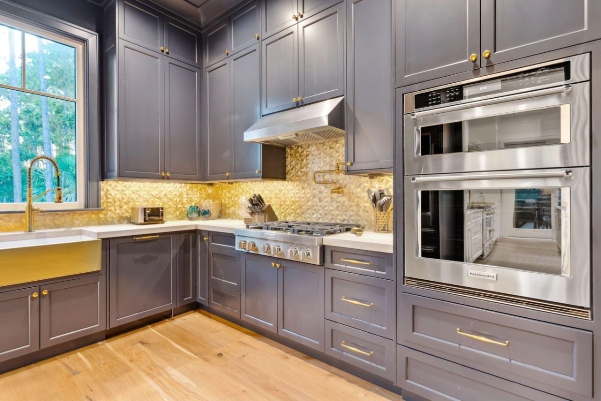 Kitchen with gold accents, sinks, custom lights and custom cabinets.