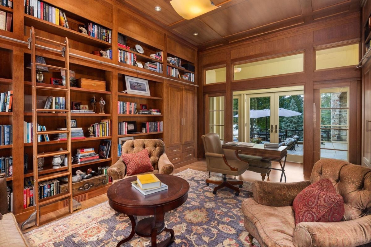 Home office with a desk, chair, couch and bookshelves.