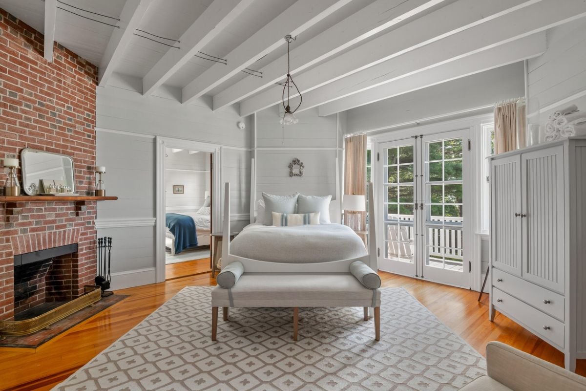 Bedroom with a large bed, glass door, custom cabinet and a large rug.