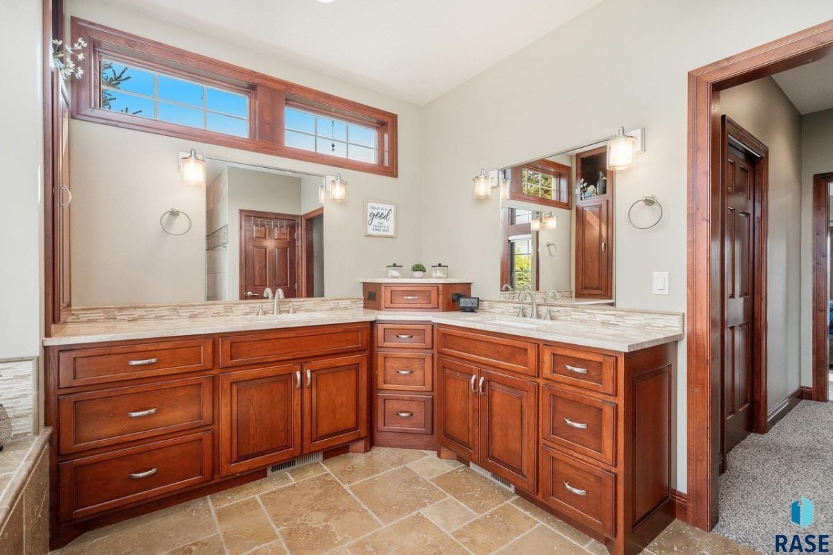 Bathroom with dual sinks, large mirrors and custom lights.