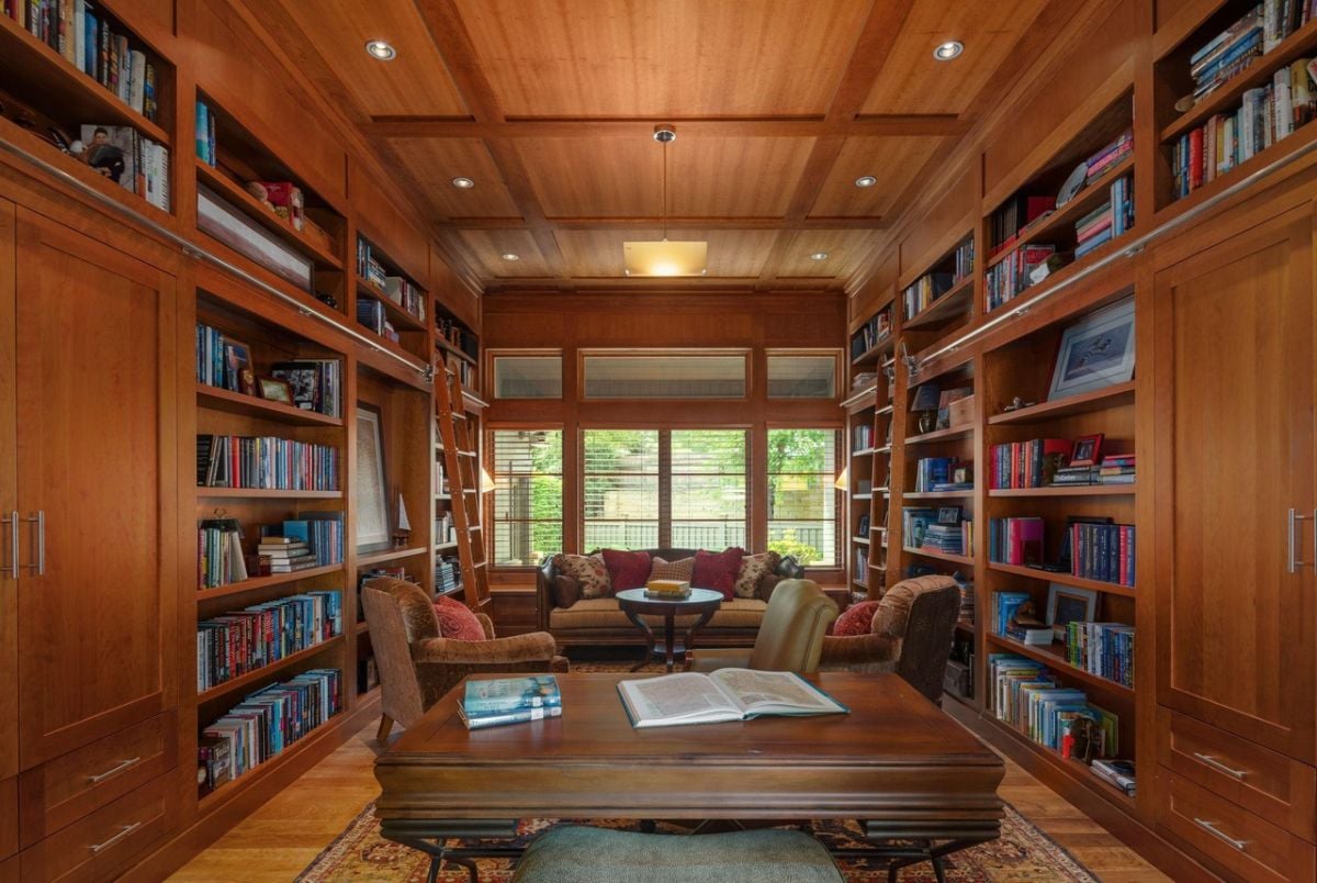 Home office with a desk, chair, couche and bookshelves.