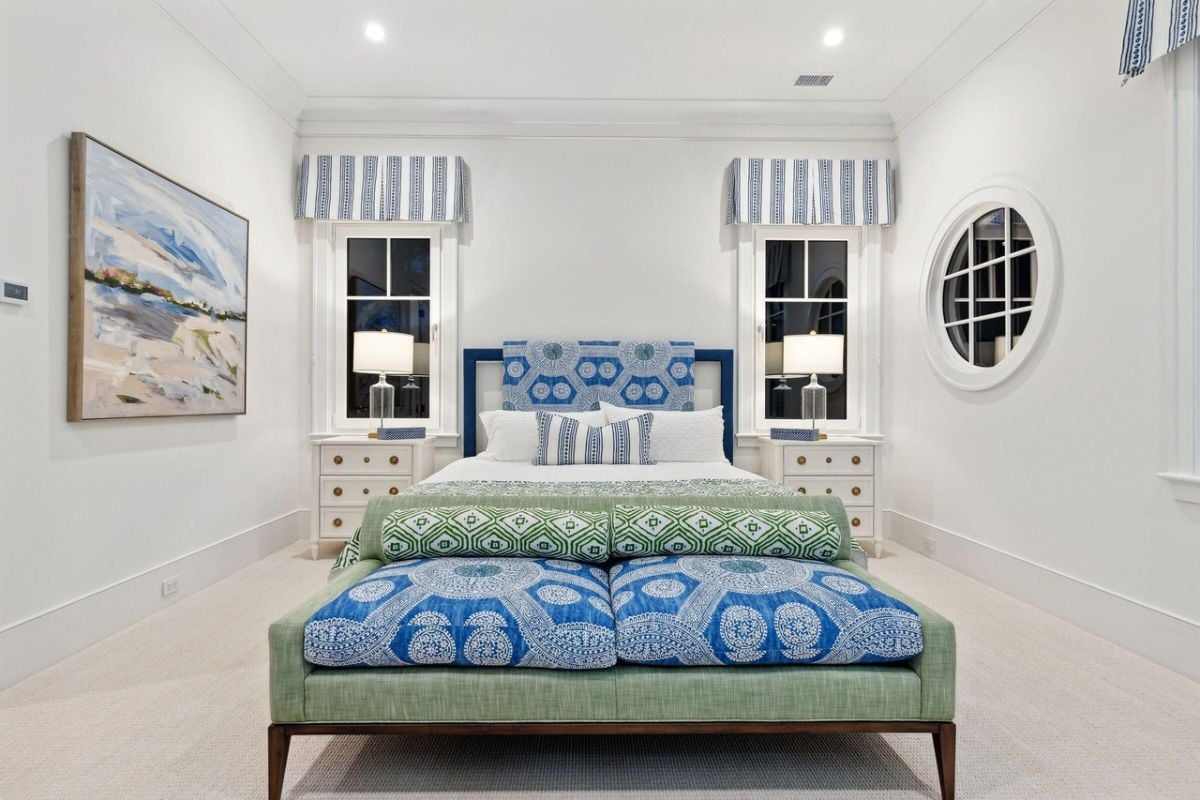 Bedroom with a large bed, carpet flooring, and glass windows.