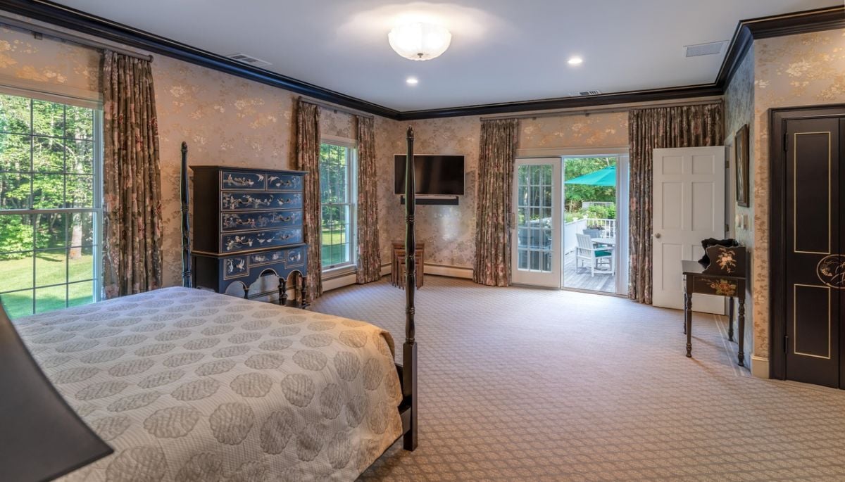 Bedroom with a large bed, custom lights, carpet flooring and a TV.