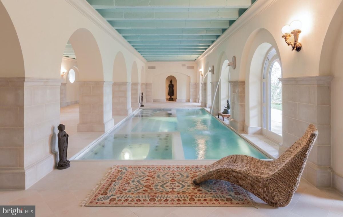 Indoor pool with a large lounge chair and custom lights.