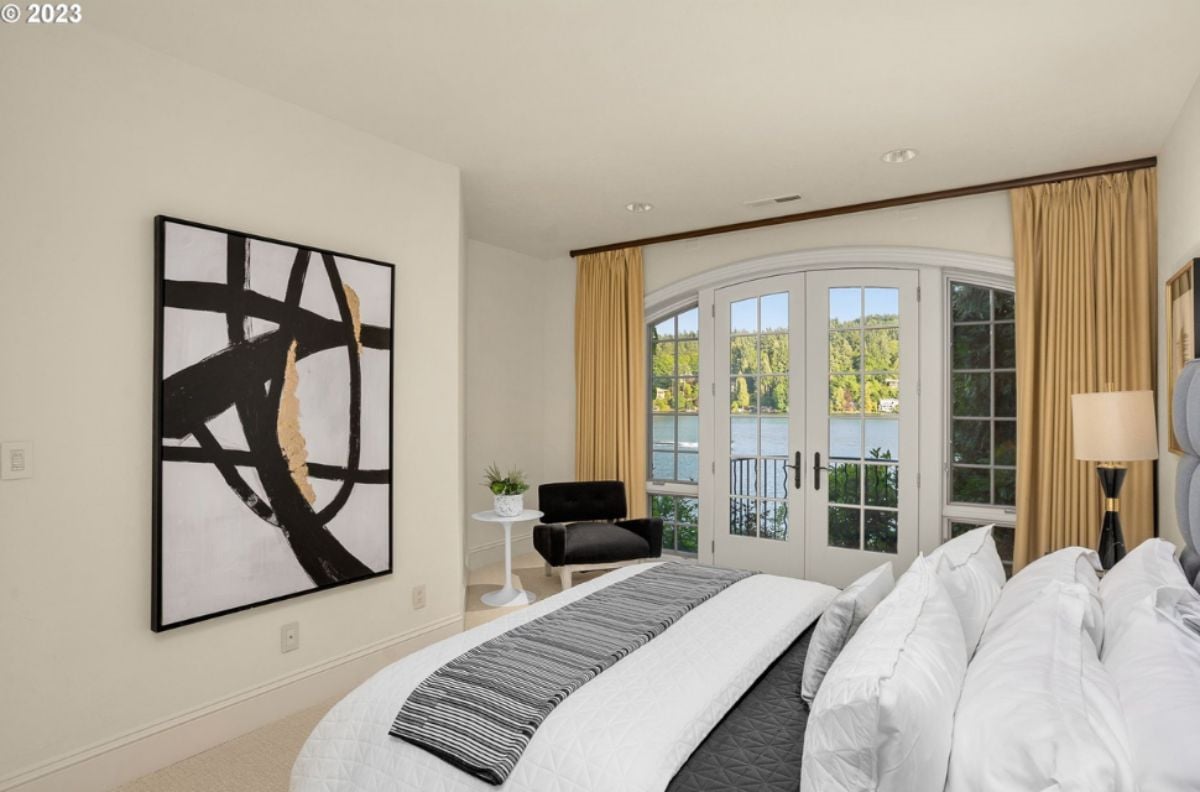 Bedroom with a large bed, custom lights, glass windows, and glass doors.