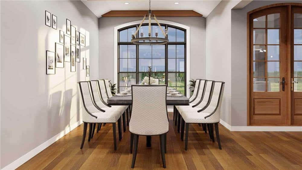 Dining room with a dark wood table, upholstered chairs, and an arched window that looks out the front yard.