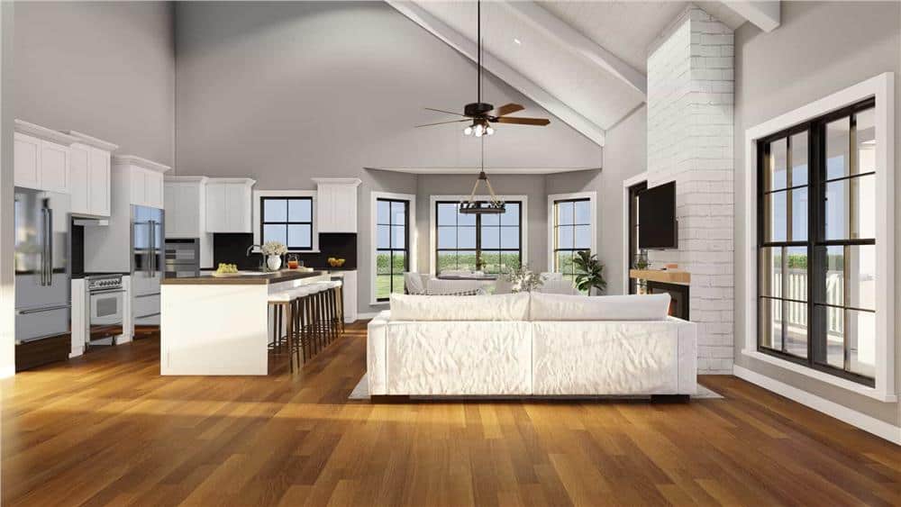 Great room and kitchen with a vaulted ceiling and surrounding windows bringing lots of natural light in.