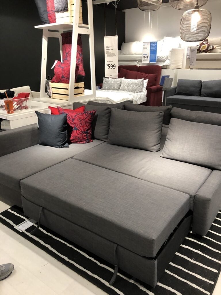 Gray IKEA futon sofa with red and blue accent pillows