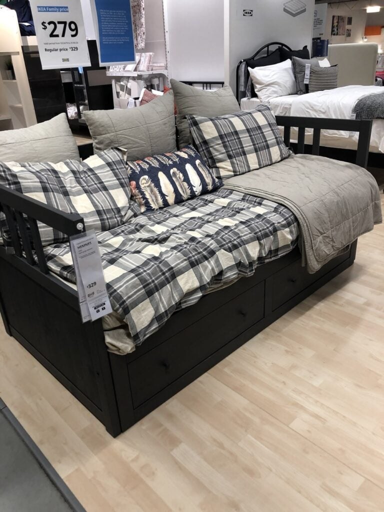 Hemmes IKEA daybed with a plaid blanket on top in the IKEA showroom