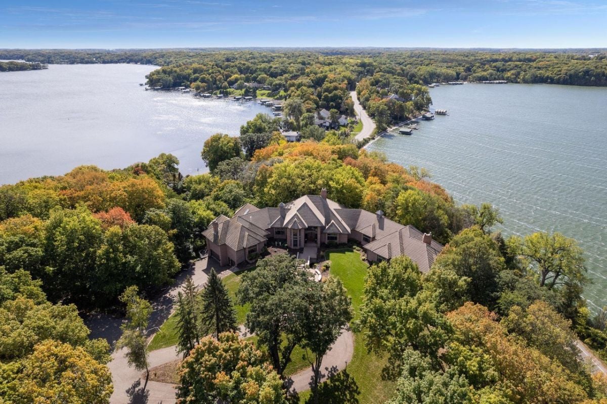 Aerial view of the mansion with a lake in the background.