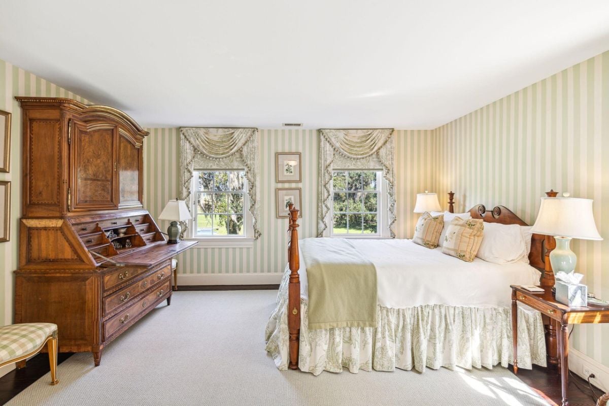 Bedroom with a large bed, carpet flooring, and glass windows.