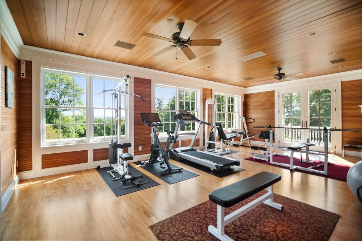Home gym with wood flooring, glass windows and workout equipment.