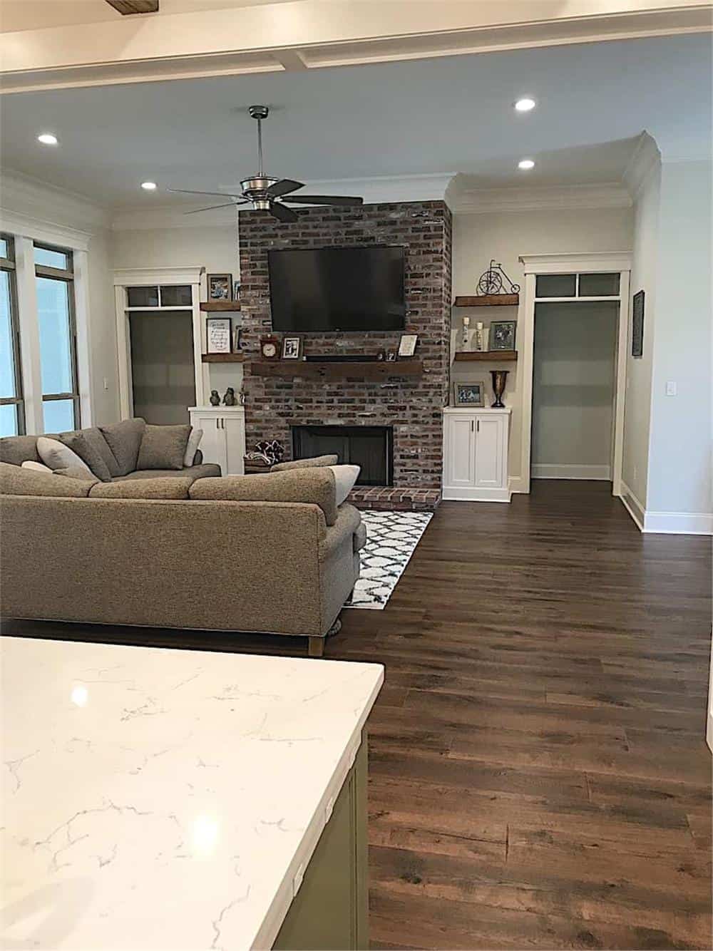 View of the living room with a brick fireplace from the kitchen.