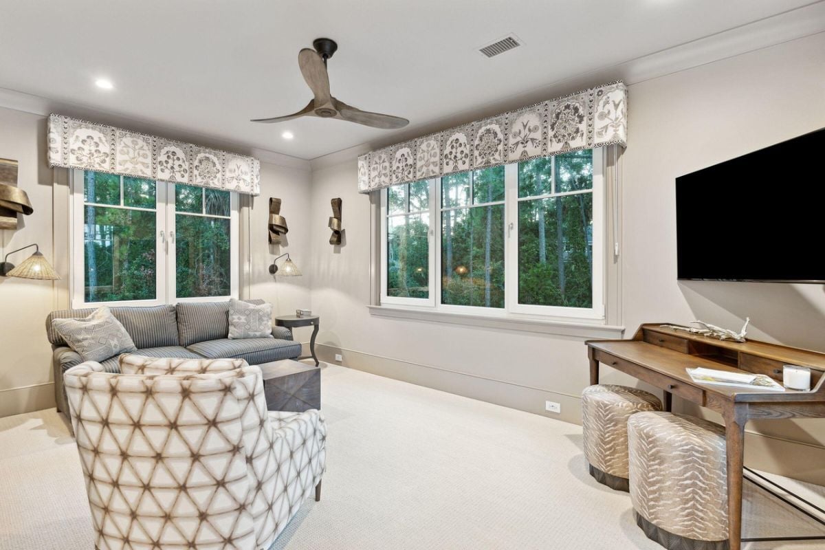 Media room with couches, a large screen TV and carpet flooring.