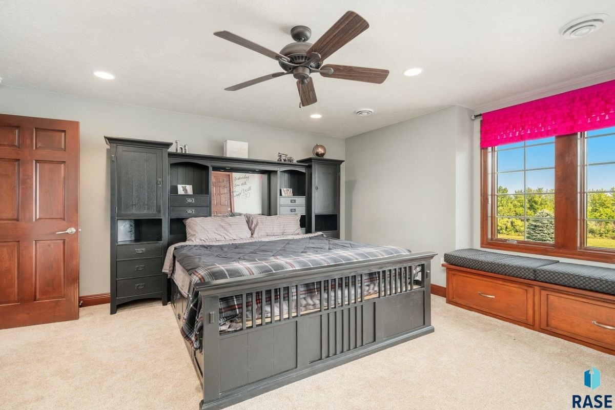 Bedroom with a large bed, carpet flooring, and glass windows.