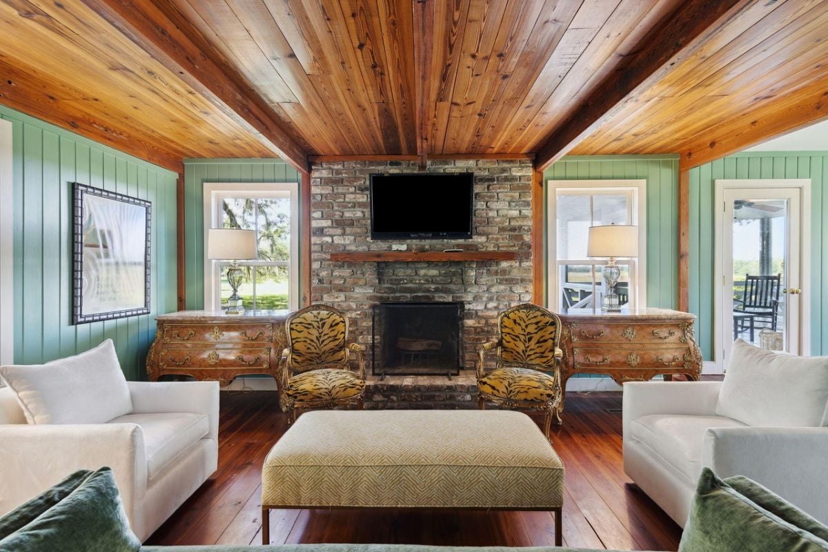Living room with couches, wood flooring and a fireplace.