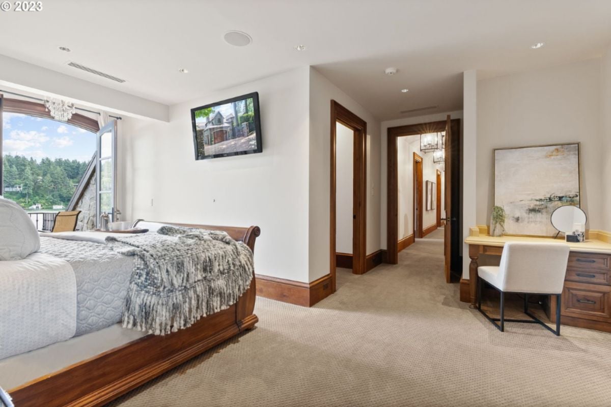 Bedroom with large bed, TV, carpet flooring and custom lights.