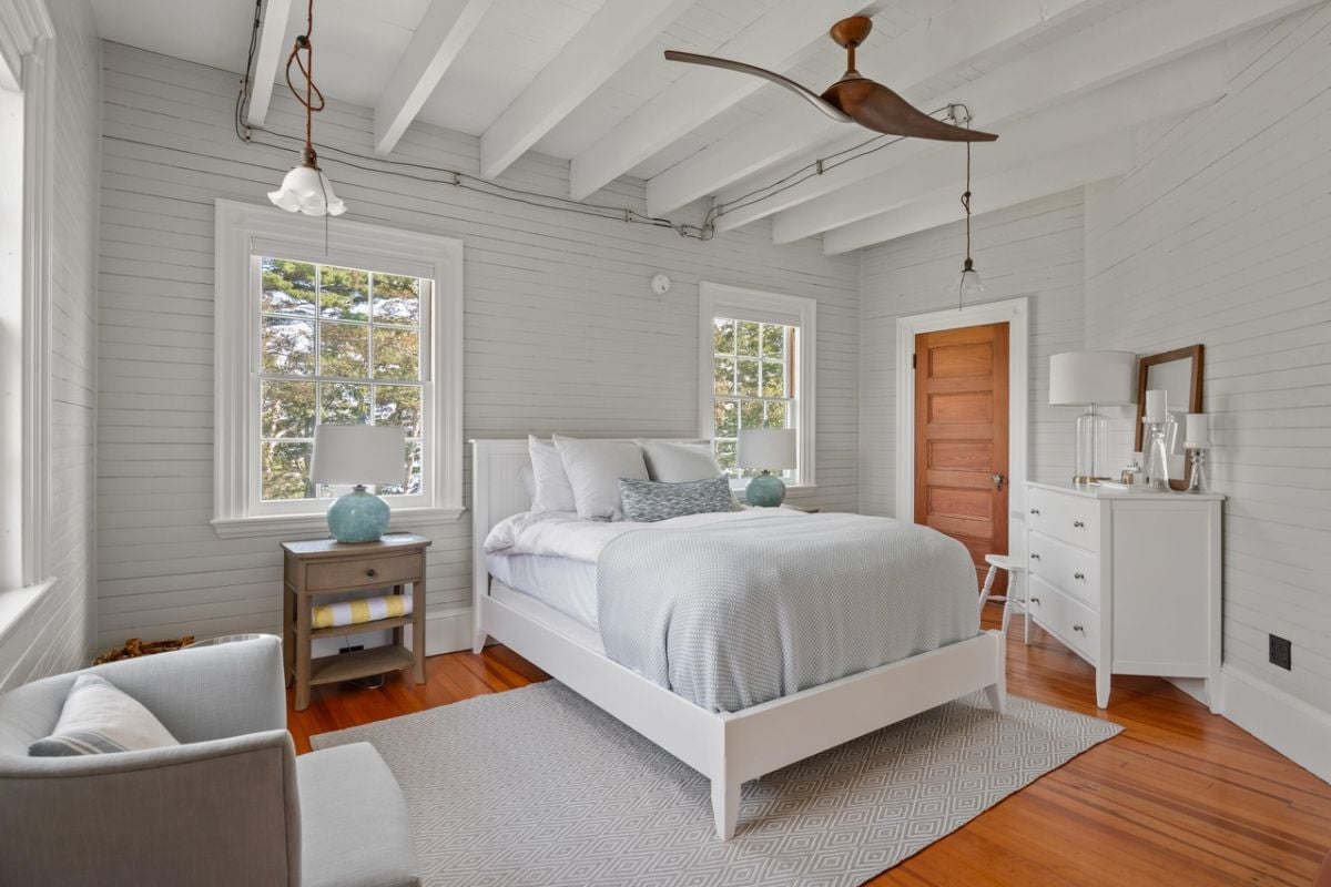 Bedroom with a large bed, wooden door, glass windows and a rug.