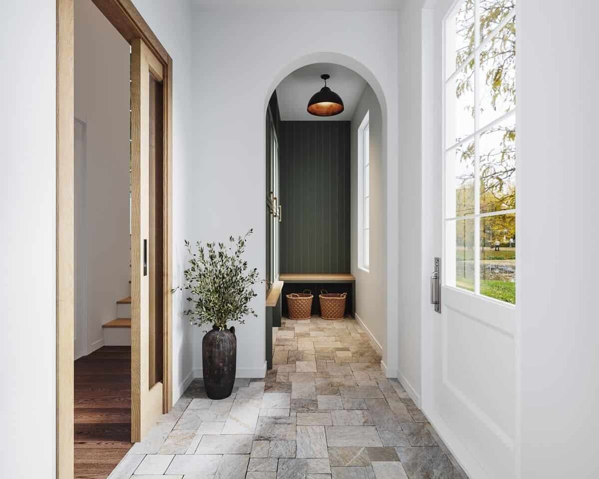 Foyer with limestone flooring and and archway leading to a built-in bench.