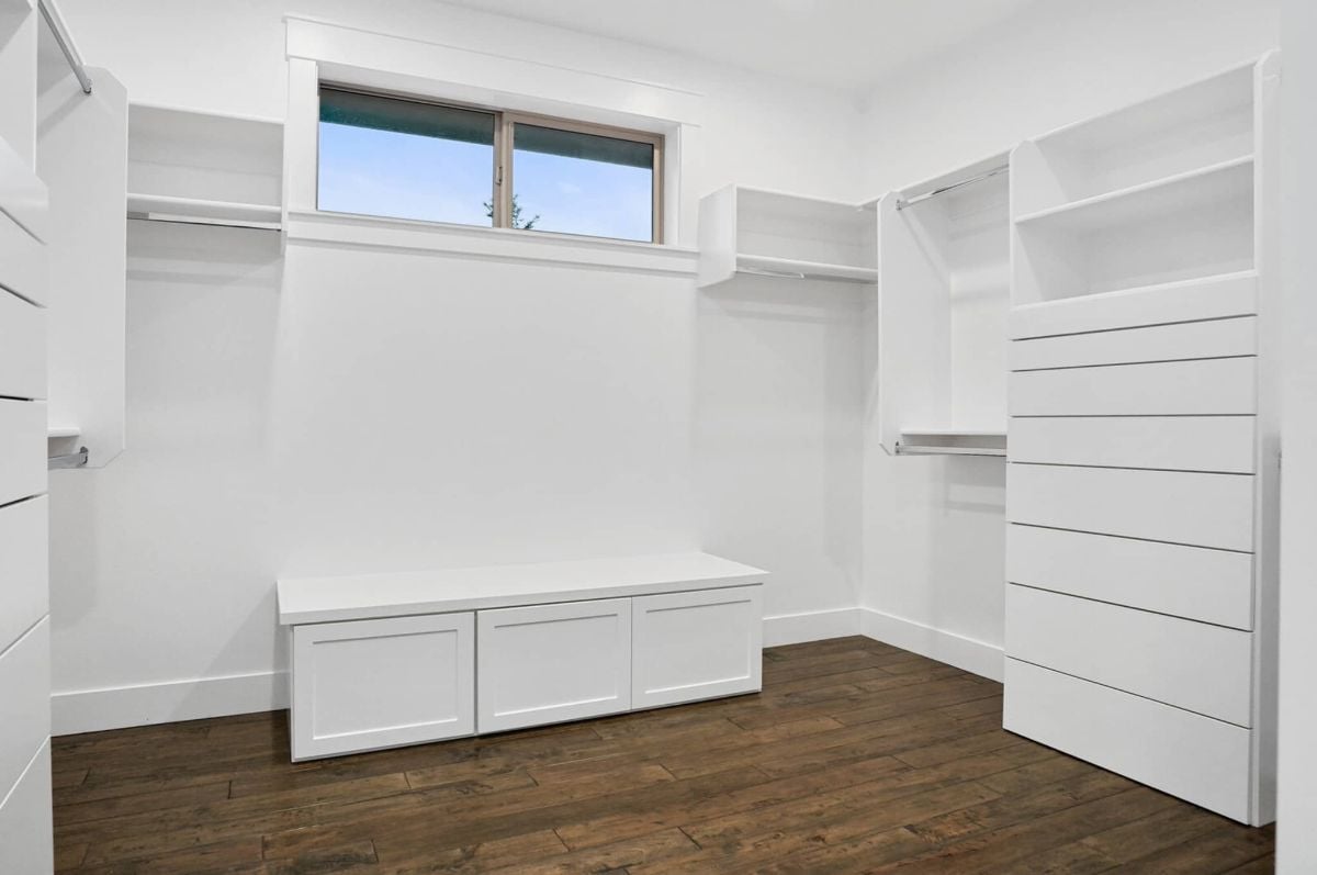 Walk-in closet with white shelves and drawers