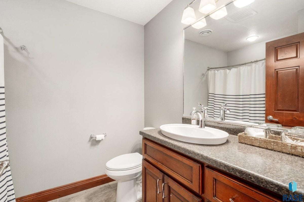 Bathroom with a sink, a large mirror and a toilet.