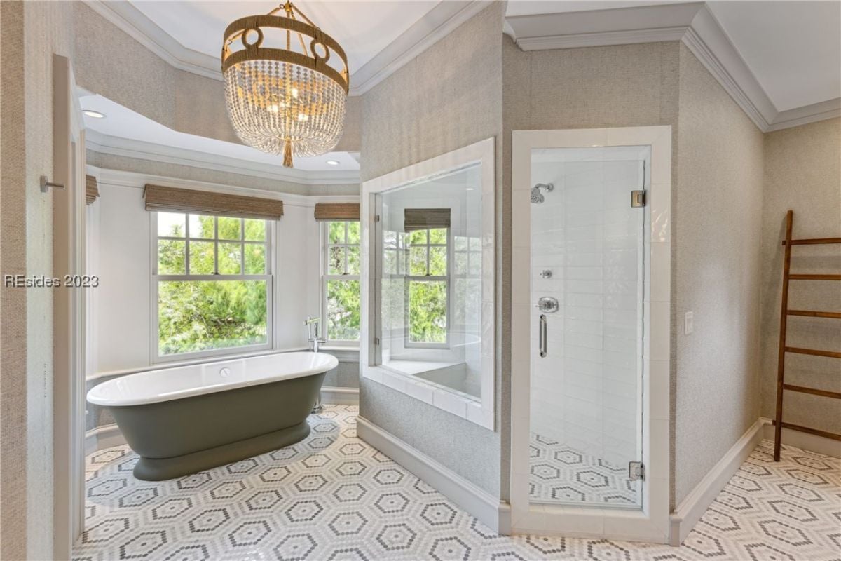 Bathroom with a chandelier, soaking tub and a walk-in shower.