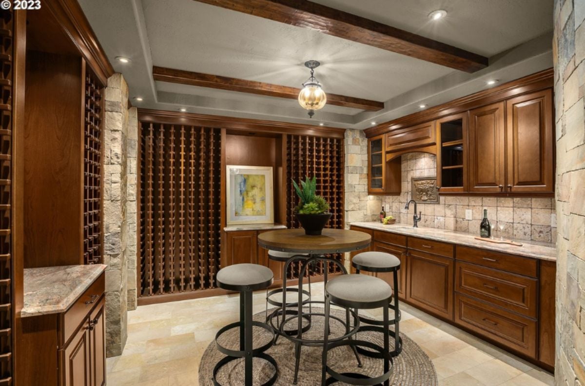 Wine cellar with a table, chairs and wine racks.
