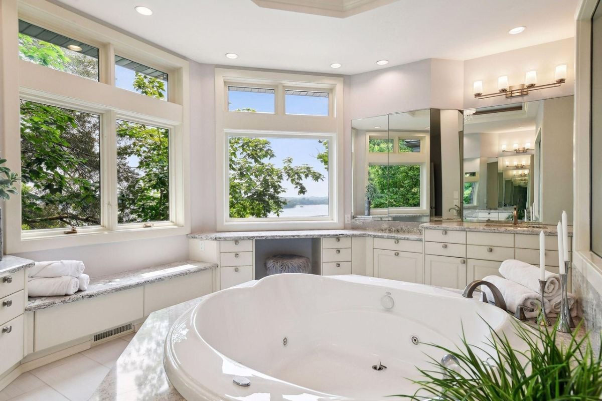 Bathroom with wooden white vanity and a soaking tub.