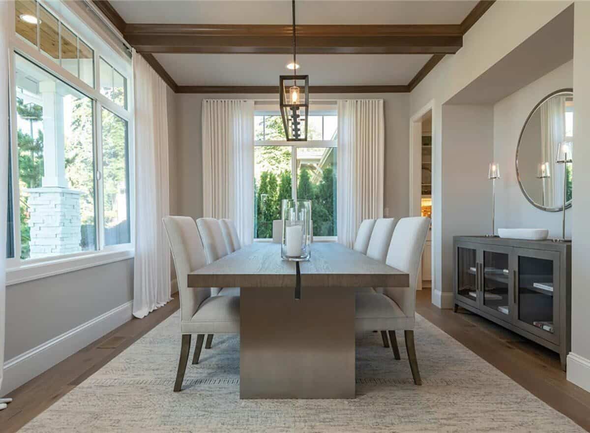 Dining room with a wooden dining set and a buffet table topped with a round mirror.